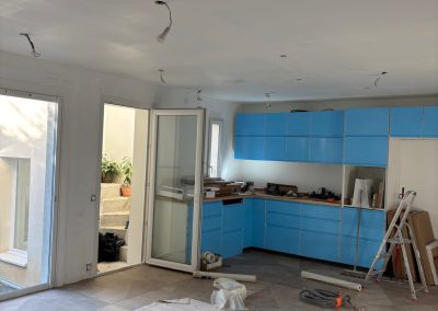 Rénovation complète d'une maison incluant démolition, installation de carrelage, électricité, plomberie, faux plafond, luminaires, cuisine, pose de baie vitrée et travaux de peinture.