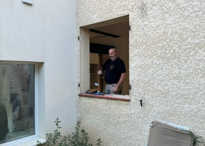 Démolition d'une fenêtre pour l'installation d'une baie vitrée.